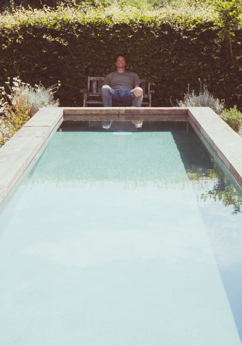 Ausschnitt eines Gartens im Sommer, Mann am Pool