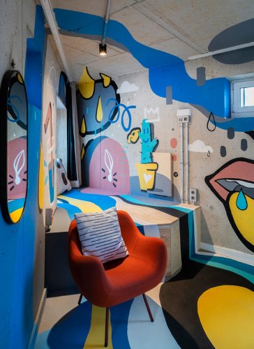 Ausschnitt einer Spitze Raumecke mit Rohbeton und buntem Graffiti in einem Artroom des Hotels Villa Viva
