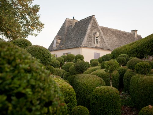 jardins de Marqueyssac, geschnittene Buchshecken mit Herrenhaus im Hintergrund